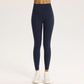 High-waisted stretch yoga leggings for women paired with white sneakers in studio