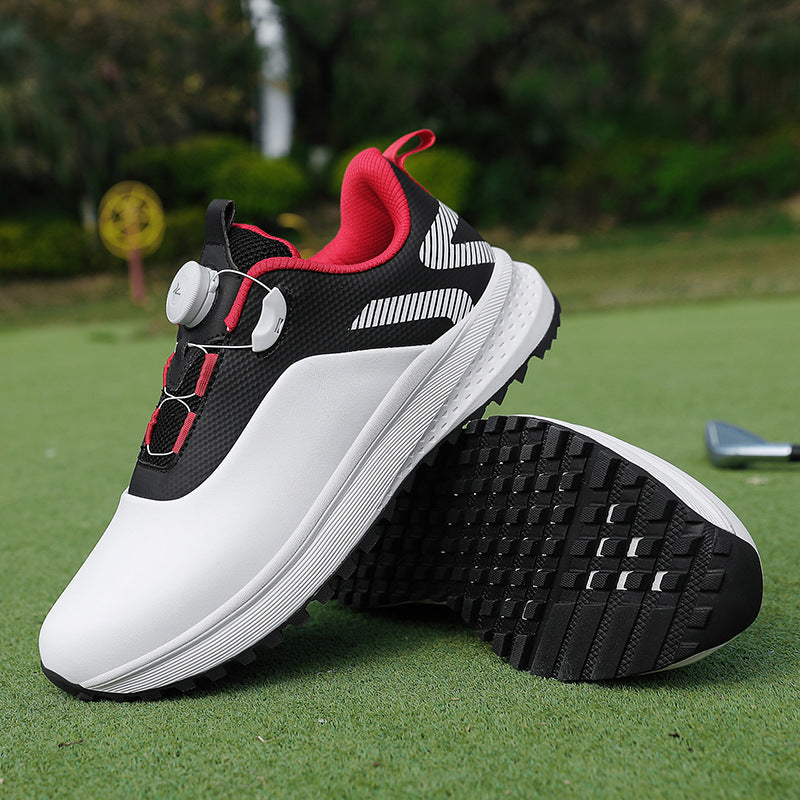 White and black golf shoe with red trim, a twist dial closure and a nubbed spikeless outsole