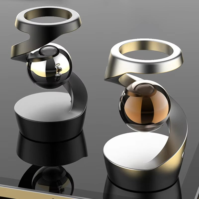 Floating bead spinning above the base of a magnetic levitation desk toy