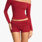 Woman in a Burgundy off the shoulder top and ruched fold-over mini shorts, three quarter view