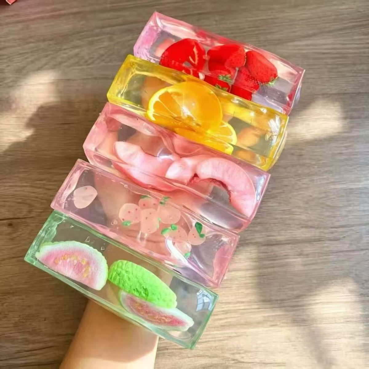 Row of fruit ice cube squishy bars in strawberry, lemon, peach and pastel styles