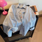 Close up of a buttoned cuff on the blue striped cotton long sleeve shirt