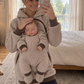Beige teddy fleece hoodie with a baby asleep at the chest while the mother takes a mirror photo in a bedroom