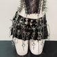 Chained punk mini skirt detail showing eyelets, silver rings and dangling cross pendants