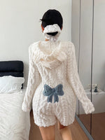 Back view of a white plush fleece hooded romper with bear ears and a blue bow patch, standing
