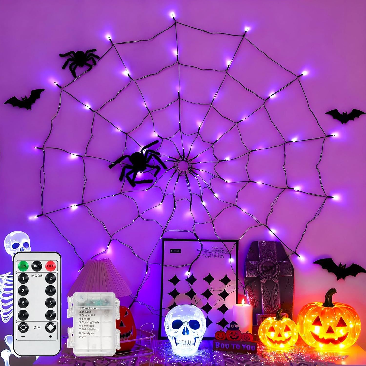 Purple lit spider web net light on a wall with bats and skulls, shown with remote and battery box