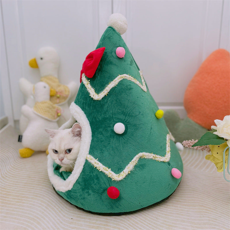 Green tree shaped pet den with a red bow and pompom baubles