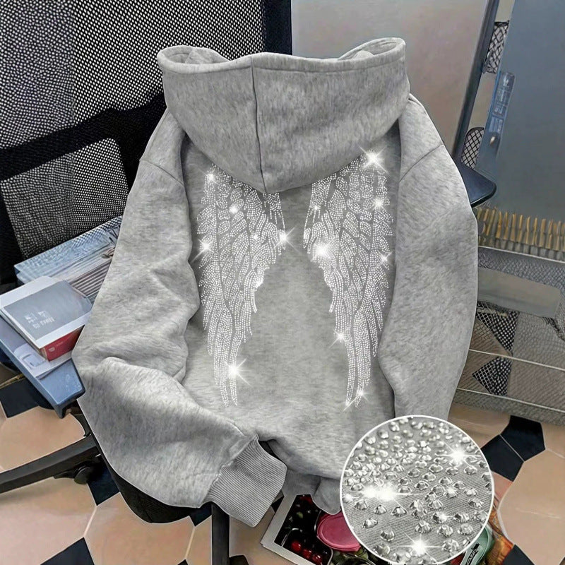 Light gray hoodie back with rhinestone wings on a chair beside a close-up of the stones