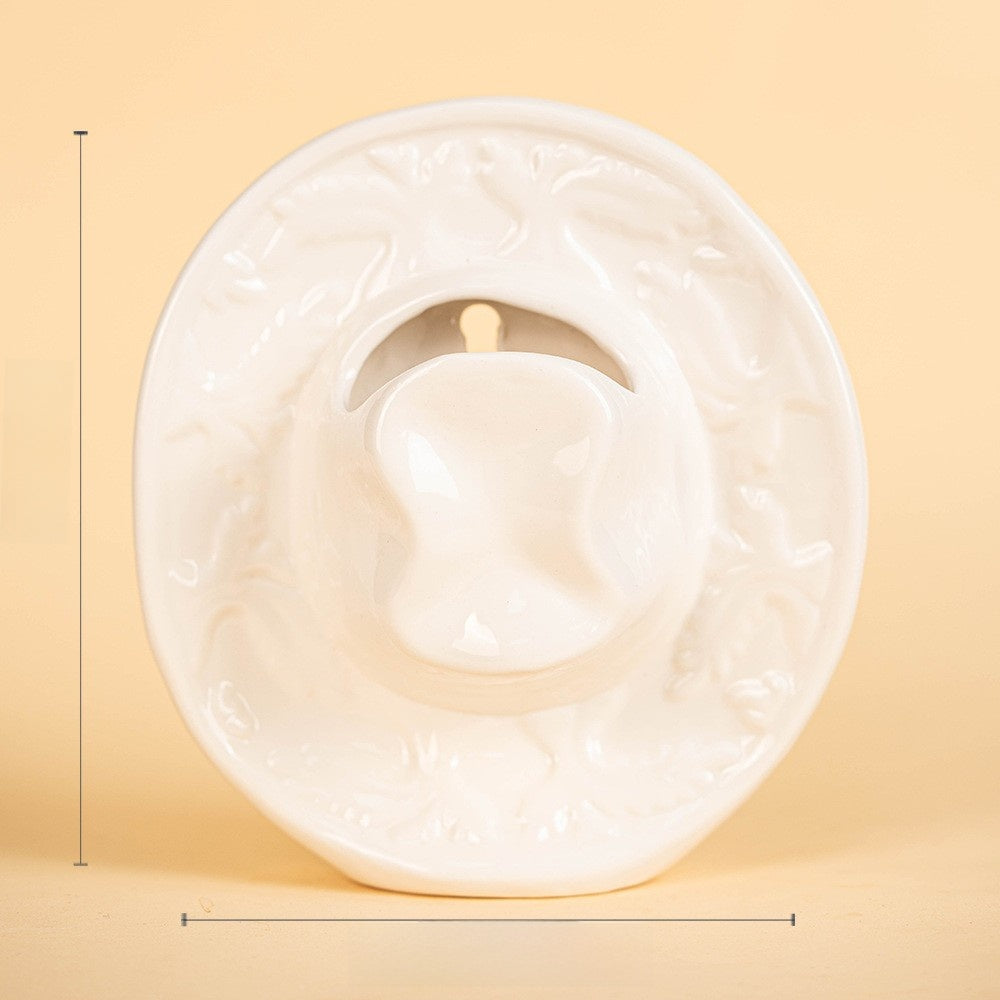 White ceramic cowboy hat vase shown empty with its overall size marked