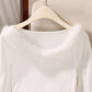 White ribbed top on a hanger showing the fluffy off-shoulder neckline trim up close