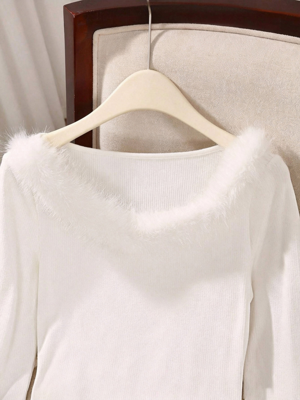 White ribbed top on a hanger showing the fluffy off-shoulder neckline trim up close