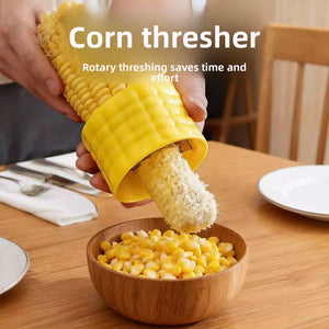 Hand twisting the yellow corn stripper down a cob as kernels drop into a wooden bowl