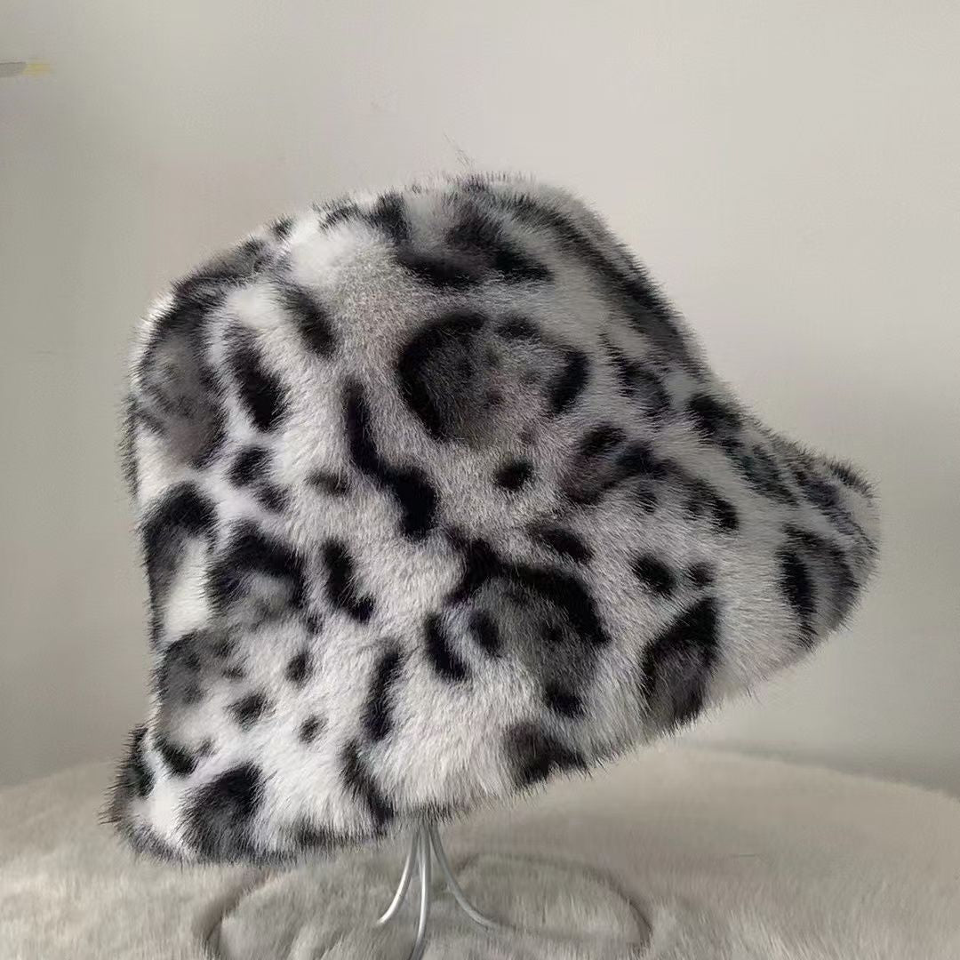 White and black leopard print plush bucket hat on a clear stand