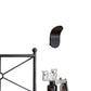 Brushed black curved wall lamp above a metal bed frame beside a small vase and framed picture