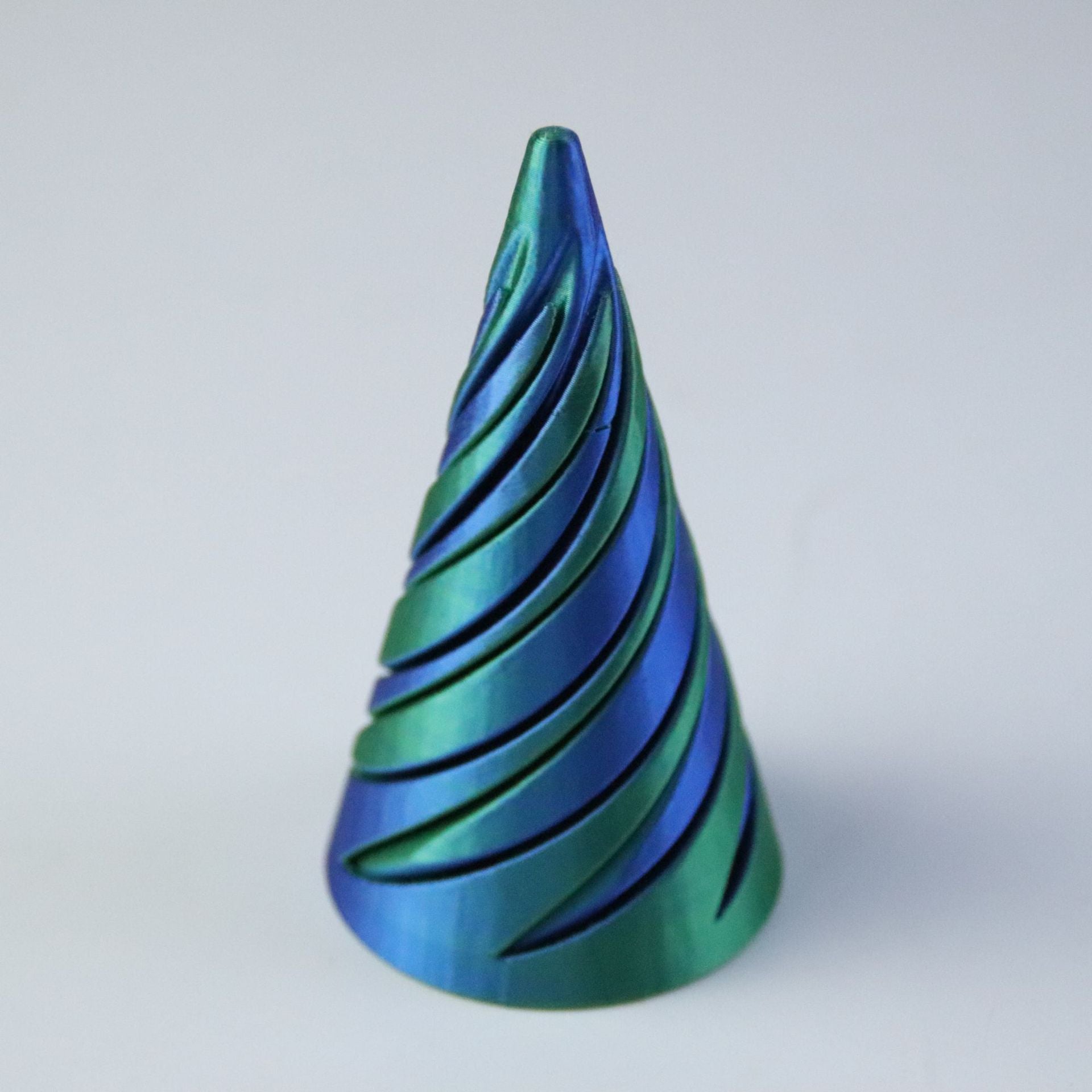 Single blue and green gradient spiral cone printed in PLA, seen from the front on grey