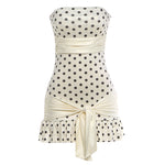 Apricot polka dot slim fit dress worn in a warm daytime lifestyle setting