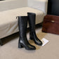 Tall black cowhide leather boot showing the round toe and high shaft below the knee