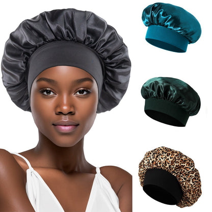 Woman wearing a dark gray satin bonnet with a wide elastic band, with teal, green and leopard thumbnails