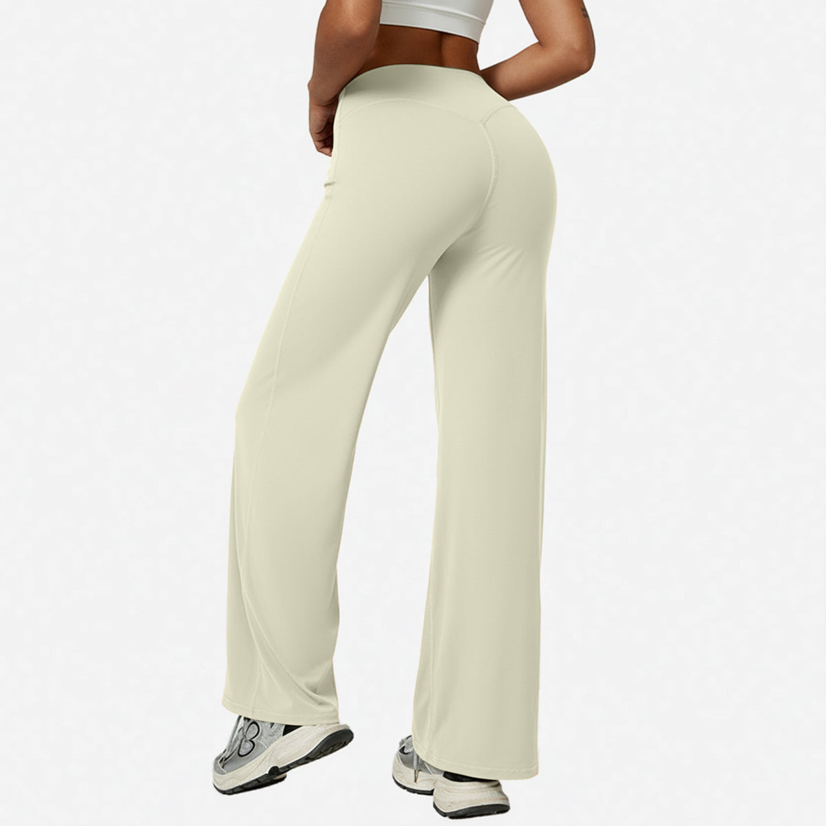 Cream apricot high-waist wide-leg flared yoga pants side view on a model in a white studio