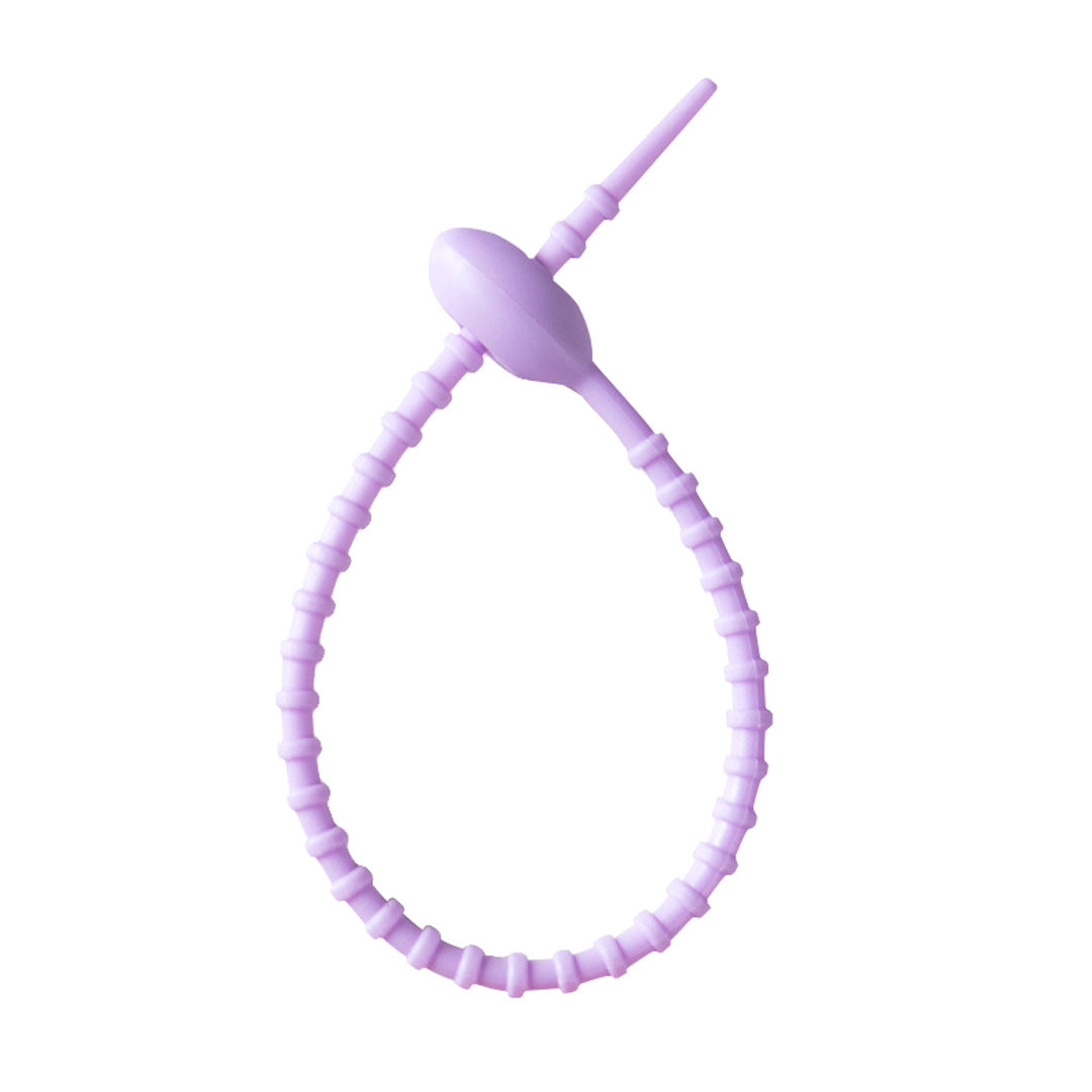 Flexible silicone cable tie shown open with the tail ready to thread through the head