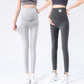 Two women in light gray and dark gray maternity leggings with belly panels, standing in white trainers