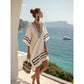 Loose V neck bohemian beach cover up dress in a gold and black stripe print, worn by the pool on a warm afternoon