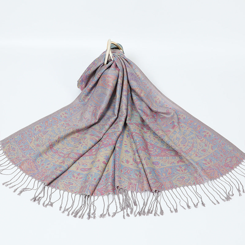 Mauve gray paisley shawl with a pastel border and gray tassels spread on a white background