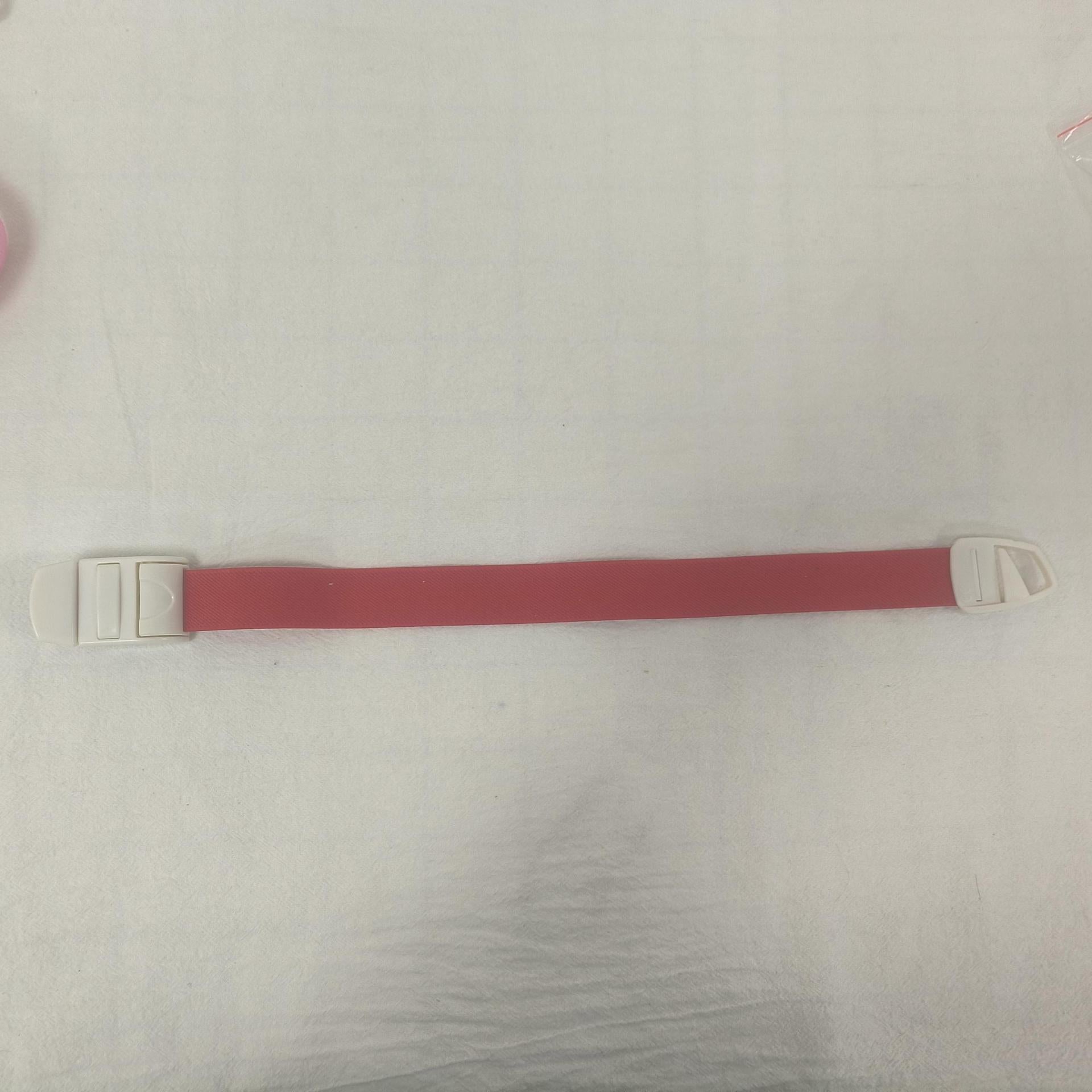 Single rose pink elastic quick release tourniquet band with a white snap buckle laid flat
