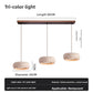 Travertine LED pendant lamp with a soft down glow over a side table and books
