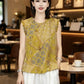 Woman wearing yellow Chinese style jacquard blouse holding a woven straw tote