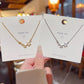 Two star necklaces on fashion accessory cards, gold tone and silver tone