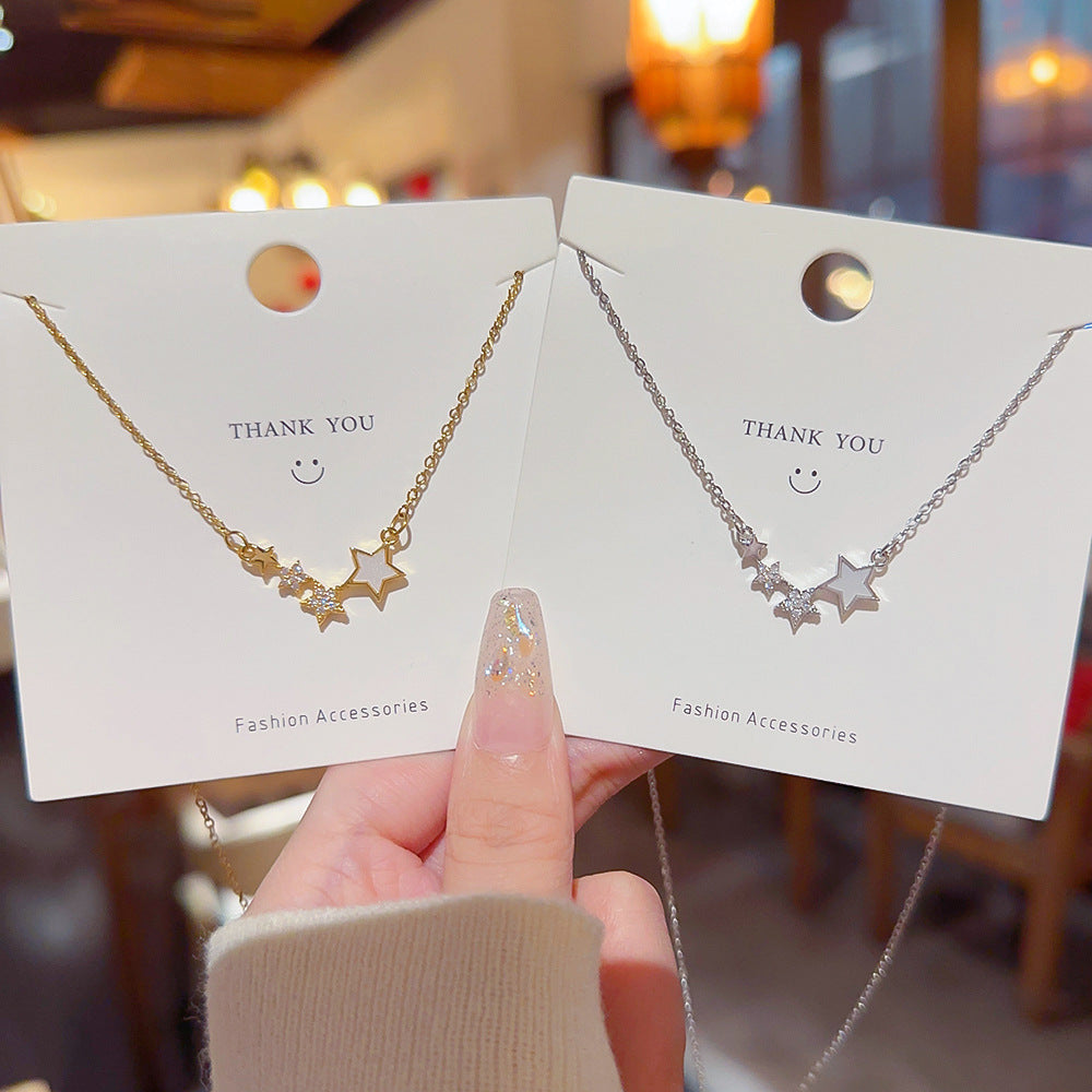 Two star necklaces on fashion accessory cards, gold tone and silver tone