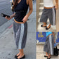 Woman in gray striped cropped pants and a black tank top on a sidewalk, with two small detail views beside her