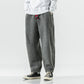 Grey plush harem pants with red drawcord, front view with white sweatshirt and high top sneakers