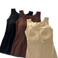 Nude, brown and black seamless tank tops on a white background, the nude top showing its built-in cups