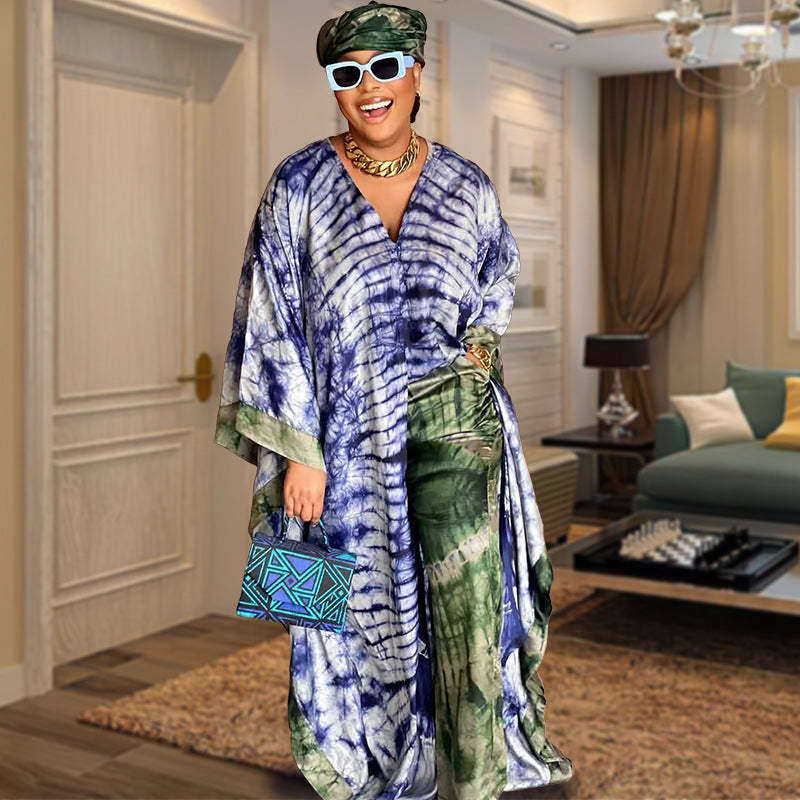 Model wears the blue and green tie dye satin caftan gown with matching wide leg trousers