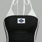 Black halterneck crop top with white side stripes and Brazil flag flat lay