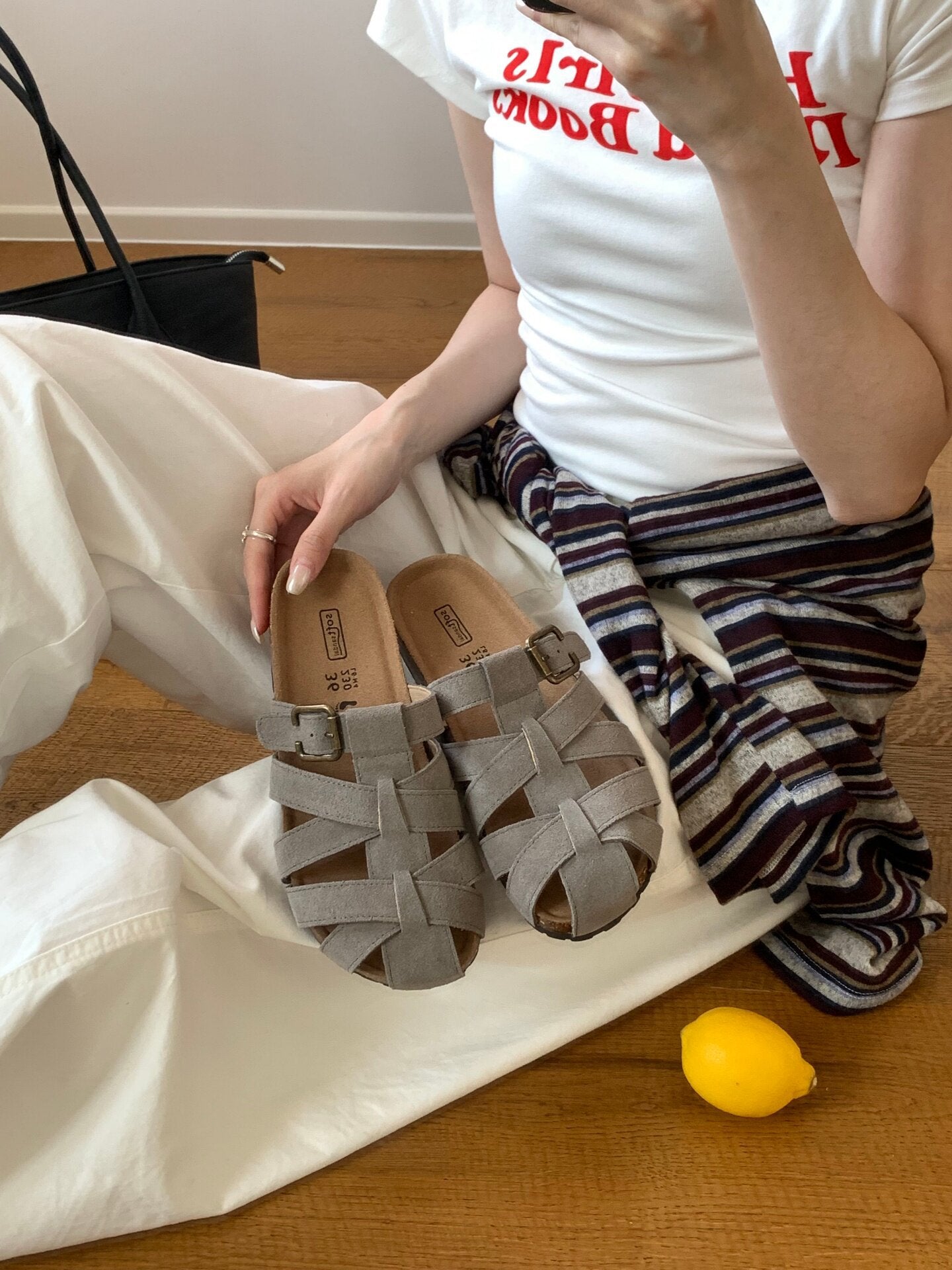 Woven slide sandals worn in an indoor setting