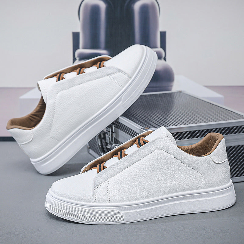 Pair of white slip-on low-top sneakers with white rubber sole resting against a metal case