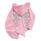 Pink hoodie back with sparkling rhinestone wings on a chair, with a stone close-up