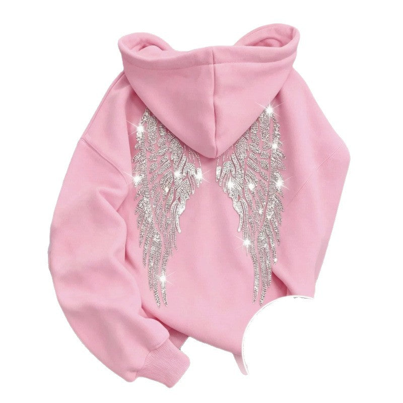 Pink hoodie back with sparkling rhinestone wings on a chair, with a stone close-up