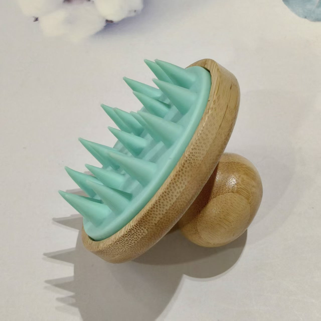 Bamboo scalp massage brush with soft silicone cones shown from the bristle side