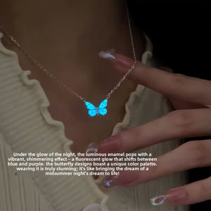 Blue butterfly pendant necklace glowing in the dark on a silver tone chain