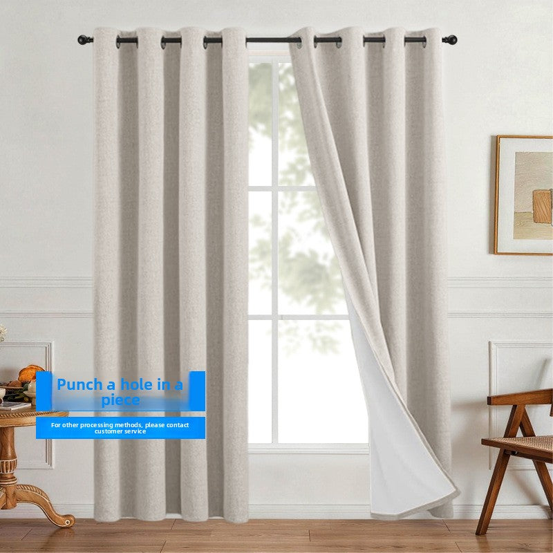 Linen look polyester blackout grommet curtain panel with white thermal backing pleated on a slim black rod over a tall window