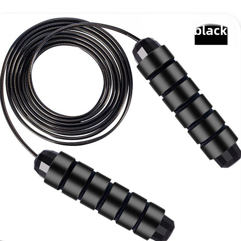 Plain black skipping rope laid flat on white with the coated steel cable coiled