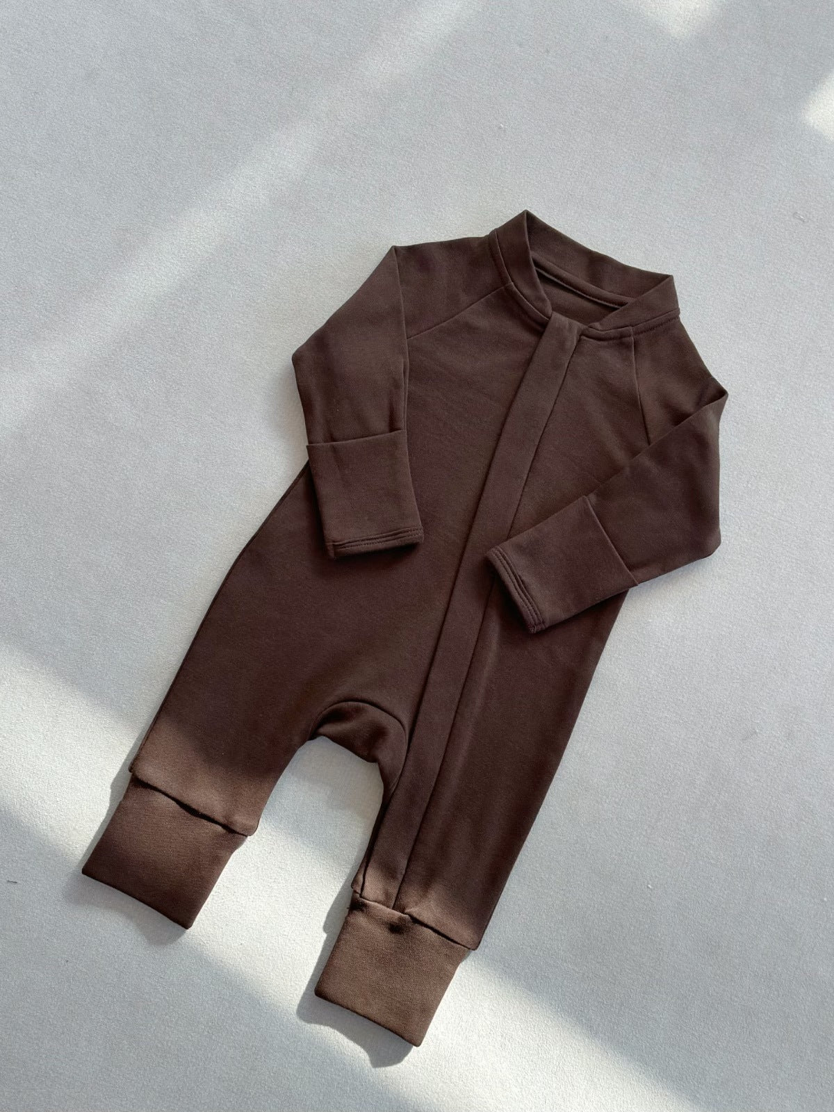 Chocolate Brown zip front baby romper laid flat on a gray floor, image of the 80 cm, 12 to 18 months size option