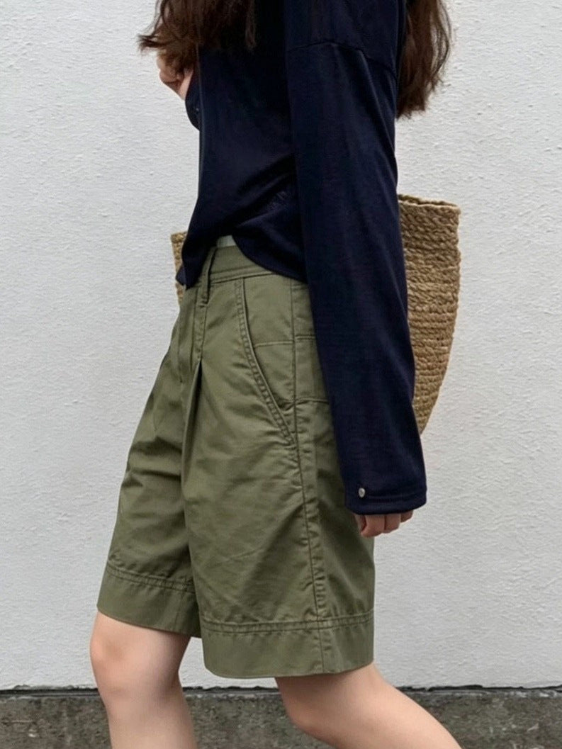 Side view of olive green high-waisted pleated Bermuda shorts with cuffed knee-length hem