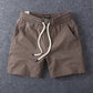 Khaki men's cotton drawstring shorts with the two open slant side pockets visible