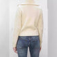 Back view of cream chunky knit cardigan with wide folded collar and ribbed hem worn over blue jeans