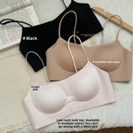 Three seamless push up bralettes in black, nude and light pink laid flat on linen